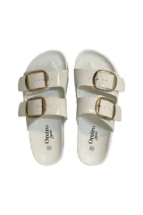 Sandalias blancas con dos tiras ajustables con hebillas doradas.