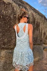 Vestido corto celeste de encaje bordado, sin mangas y con volados en la falda. Incluye un top y una calza tipo biker que se usan por debajo.