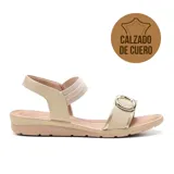 Sandalia de cuero color beige, con tira ancha elástica en el empeine y hebilla circular dorada.