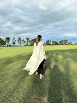 Zapatillas bajas con estampado animal print de vaca en blanco y negro, con cordones marrones y suela color caramelo.