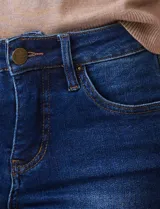 Jean skinny de mujer, color azul oscuro con efecto lavado, tiro medio, con pretina, botón, cierre y bolsillos delanteros y traseros.