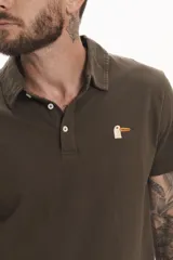 Chomba de piqué color marrón con cuello clásico y cierre de botones. Tiene un pequeño bordado de un pato en el pecho.