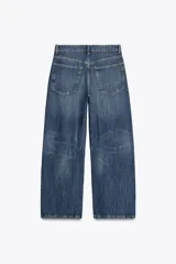 Pantalón de jean celeste de corte amplio, tiro medio, con cinco bolsillos y detalle de costuras torcidas.