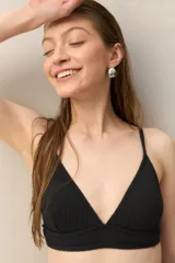 Top de bikini negro de textura tramada, con breteles finos regulables y diseño de triángulo.