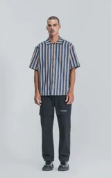 Camisa de manga corta con cuello cubano y estampado a rayas verticales en tonos azul, amarillo y rojo.