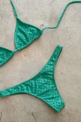 Conjunto de bikini verde esmeralda, con corpiño triangular de atar al cuello y espalda, con almohadillas desmontables, y bombacha colaless con laterales fijos.
