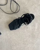 Sandalias negras con tiras finas y taco aguja de 9 cm.