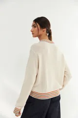 Bomber color crudo de tejido de punto con cierre frontal, cuello, puños y ruedo acanalados con rayas de colores.