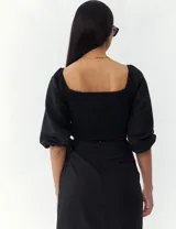 Top turquesa con escote cuadrado, mangas abullonadas y cuerpo fruncido.