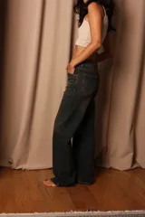 Pantalón de jean de tiro alto con lavado oscuro y detalles de desgaste.