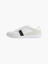 Zapatillas urbanas Calvin Klein color blanco con detalles en cuero sintético y gamuza color crema. Presentan una franja lateral negra con el logo de la marca.