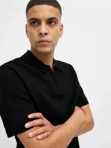 Polo negro de punto con cierre de cremallera, cuello polo y mangas cortas.