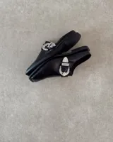 Sueco de cuero vacuno color negro con hebilla plateada con strass.