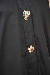 Camisa extra larga color beige, estilo vestido, confeccionada con botones tipo prendedor.