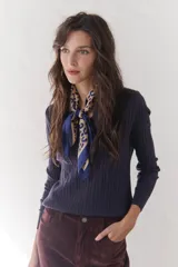 Sweater de punto marrón con escote en V y mangas largas.
