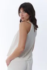Blusa color crudo con breteles finos y escote halter.