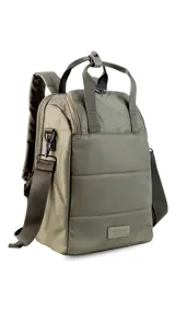 Mochila matera confeccionada en tela impermeable color beige, diseñada con dos compartimientos independientes para el kit de mate y objetos personales. Cuenta con bolsillos internos, asas de mochila acolchadas, asa de mano superior y una correa ajustable extraíble para llevar al hombro.