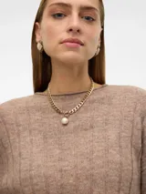 Sweater de punto color beige, con cuello redondo, mangas largas y puños acanalados.