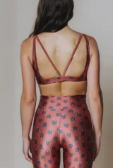Top deportivo color ladrillo con estampado de cachemir en tonos azules, escote en U, breteles medios y tiras cruzadas en la espalda.