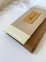 Billetera beige, crema y marrón con cierre de broche y monedero externo.