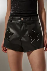 Short negro de cuero sintético con apliques de estrellas con tachas.