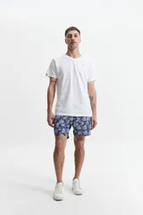 Short de baño azul marino con estampado de hojas en tonos beige y blanco. Cuenta con cintura elástica ajustable con cordón, dos bolsillos laterales y uno trasero. Confeccionado en tela ligera de secado rápido y logo bordado.
