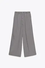 Pantalón de tiro medio con cintura elástica y bolsillos laterales ocultos en costura. Pierna ancha y diseño a rayas verticales azules y blancas.
