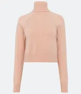 Blusa de punto color blanco, con cuello alto, manga larga y diseño liso.