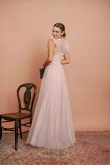 Vestido largo de fiesta color rosado con lunares blancos. Tiene cuerpo de micro tul bordado con volados en los hombros y falda de tul con forro. Incluye cinturón de raso al tono.