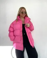 Campera puffer verde, de corte oversize, con cuello alto y cierre frontal con botones a presión y cremallera.