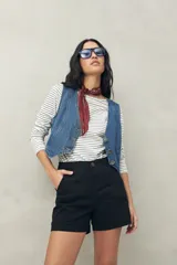 Short negro de tiro medio, con calce al cuerpo y dobladillos en los bordes.