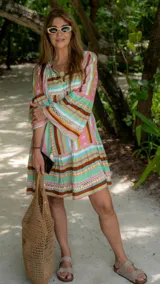 Vestido corto con estampado multicolor, escote en V con cordones y mangas amplias.