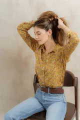 Camisa amarilla con estampado de flores pequeñas en tonos rosados y blancos, de corte clásico y manga larga.