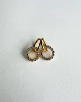 Par de aros colgantes con argollas doradas y dijes circulares de resina transparente con incrustaciones de strass de colores. El dije mide aproximadamente 1.5cm de diámetro.