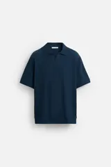 Polo azul marino de punto con textura acanalada vertical, corte regular fit, cuello solapa con abertura frontal y mangas cortas.