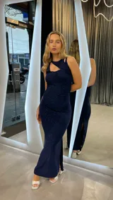 Vestido largo azul con brillos, de corte ajustado, con un solo hombro y abertura lateral en la falda.