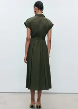 Vestido camisero midi color verde oliva, con cuello camisero, mangas cortas con dobladillo, cierre frontal con botones y cinturón de lazo.