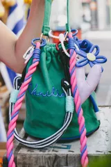 Cartera tipo tote bag color rosa claro, con cordones de colores y bordado verde con la palabra "Vanilla".