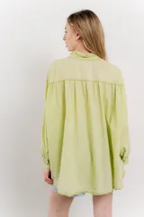 Camisa oversize de algodón color verde lima, con cuello mao con volados y pliegues verticales en el frente.