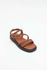 Sandalias color beige con plataforma negra, tiras trenzadas y ajuste con velcro en el talón.