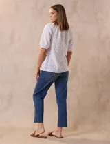Blusa blanca labrada con cuello a la base, abertura central con botones y mangas cortas. Marca Sabrina Lauren.