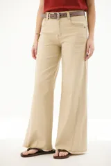 Pantalón de jean acampanado color caramelo con cintura alta y cinturón marrón con tachas.