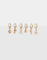 Set de aros dorados tipo argolla con dijes colgantes: corazón con strass, moño, perla, rosa, rayo y perla irregular.