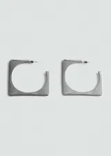 Par de aros plateados con forma cuadrada y diseño de aro.