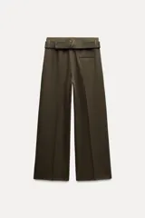 Pantalón de tiro medio color verde oliva, con cintura con trabillas, bolsillos laterales ocultos, cinturón ajustable con hebilla metálica, pinzas delanteras y cierre frontal con cremallera, botón y gancho metálico.