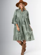 Vestido midi color verde oliva con cuello mao, corte amplio y apliques de flores con textura.