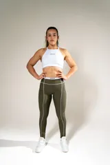 Top deportivo blanco con cuello halter y logo de la marca en el frente.