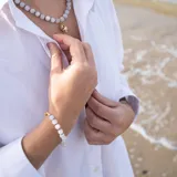 Pulsera con cuentas de piedra de la luna de 6 mm de diámetro, separadores de hilo azul, y cierre de acero hipoalergénico con baño de oro.
