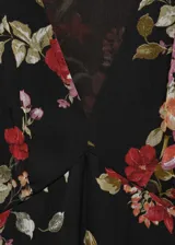 Vestido midi de gasa color negro con estampado floral en tonos rojos, rosados y verdes. Tiene escote en V, mangas largas abullonadas y corte evasé.