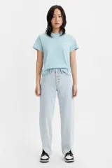 Pantalón jean celeste de corte ancho, con tiro medio, cierre con botones y aberturas en el ruedo.